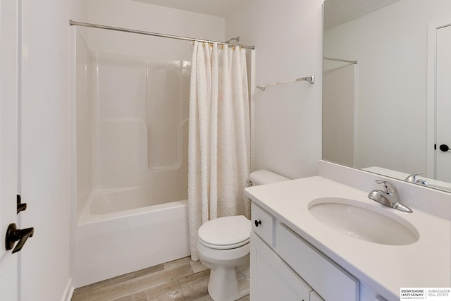 full bath featuring toilet, shower / bath combo, wood finished floors, and vanity