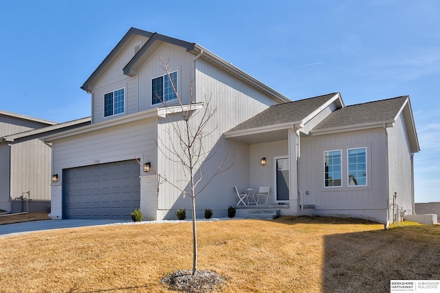 view of front of home featuring a front lawn, a garage, driveway, and roof with shingles