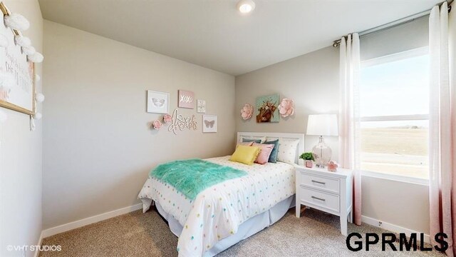 bedroom with baseboards and light colored carpet