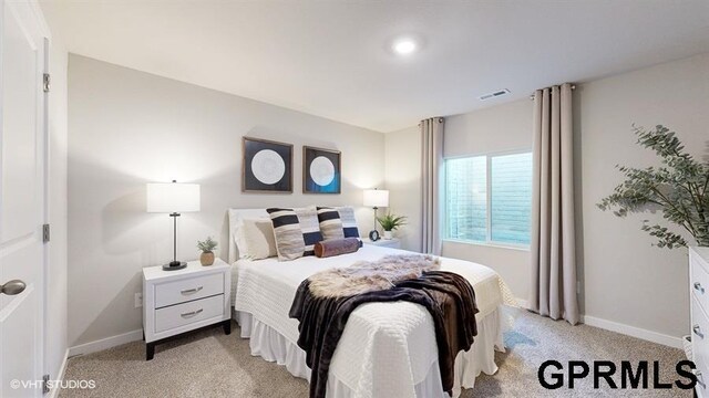 bedroom with light carpet, visible vents, and baseboards