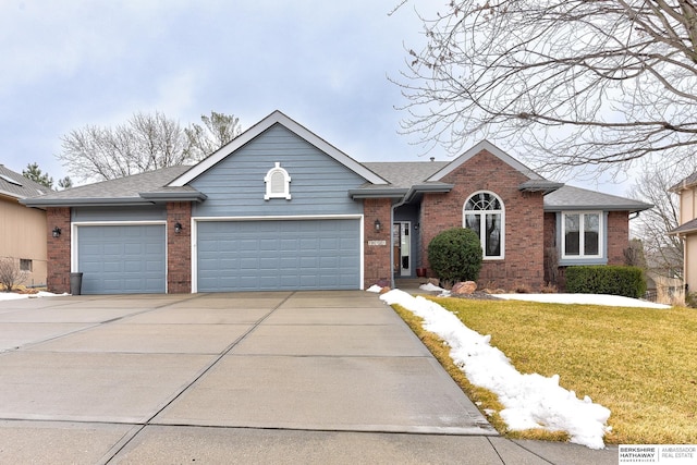 ranch-style home featuring a front yard, a garage, brick siding, and driveway