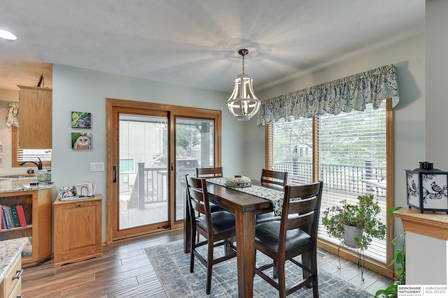 dining room with light wood finished floors and a textured ceiling