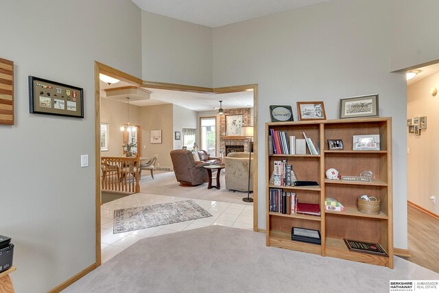 interior space featuring tile patterned floors, baseboards, carpet floors, and a towering ceiling