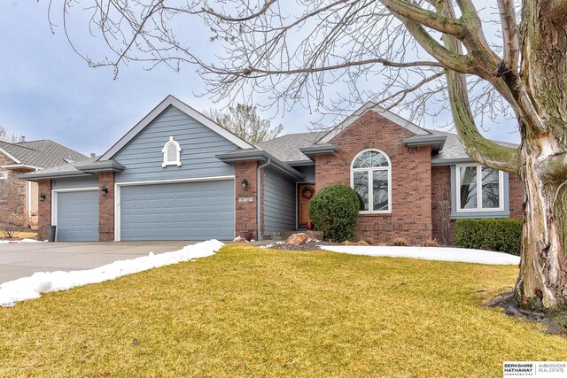 ranch-style house with a front yard, an attached garage, brick siding, and concrete driveway