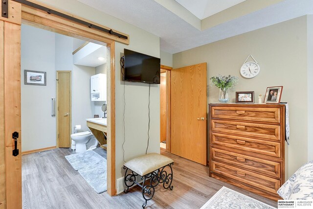 interior space featuring a barn door, baseboards, and light wood-style flooring