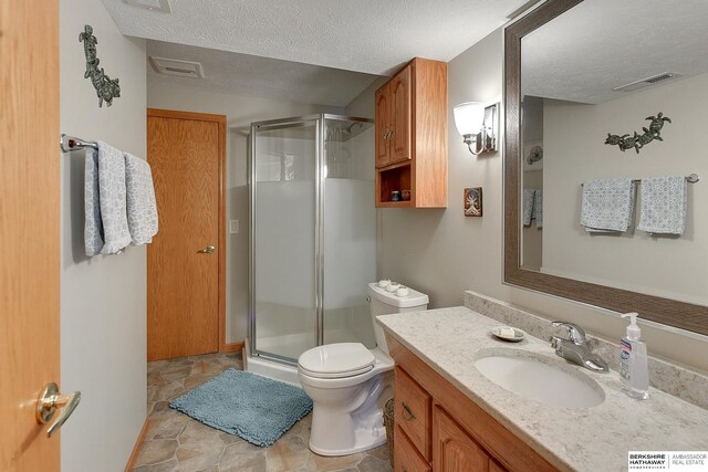 full bathroom with a textured ceiling, visible vents, and a stall shower