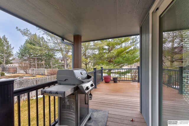 wooden terrace with a lawn and grilling area