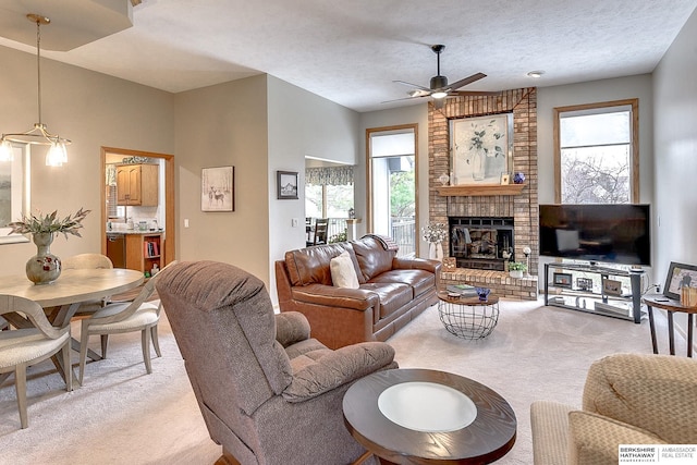 living room with light carpet, a textured ceiling, ceiling fan, and a fireplace