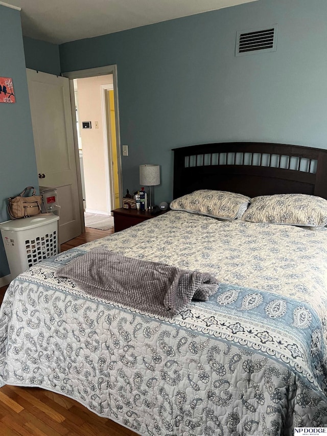 bedroom featuring visible vents and wood finished floors