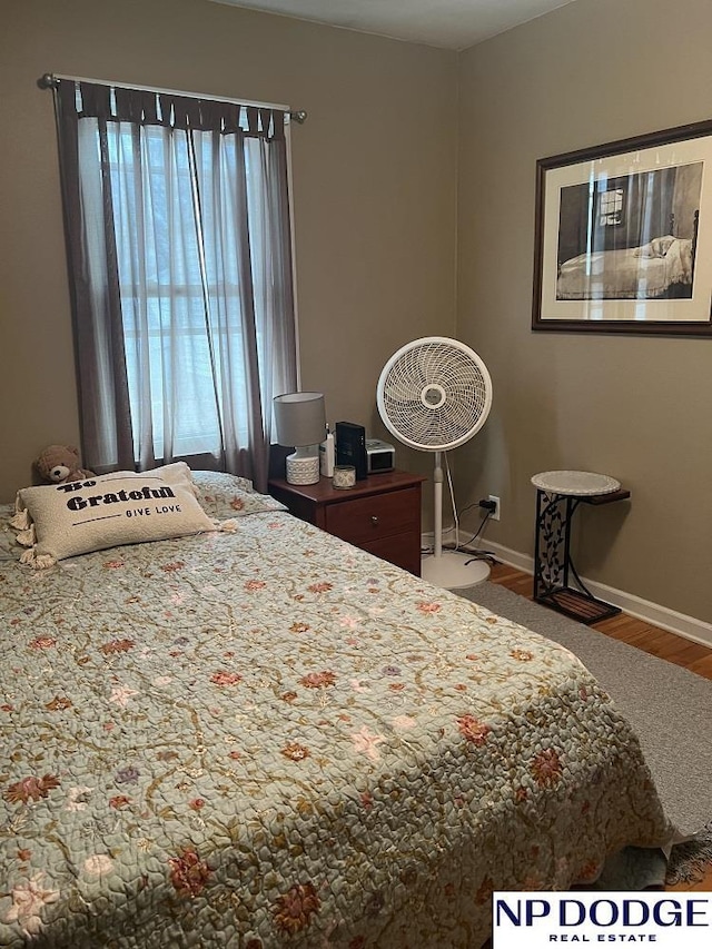 bedroom with wood finished floors and baseboards