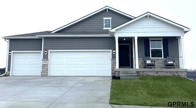 view of front of home featuring stone siding, a porch, driveway, and a garage