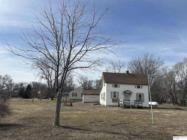 view of front of property featuring a front yard, roof with shingles, and a chimney