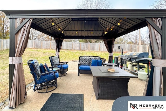 view of patio featuring a gazebo, an outdoor hangout area, and a fenced backyard