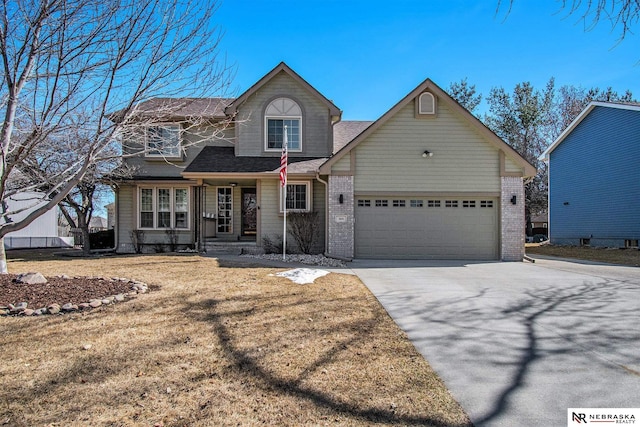 traditional home with a front yard, an attached garage, brick siding, and driveway