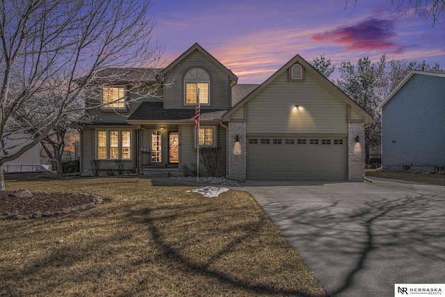 view of front of property with brick siding, an attached garage, and driveway