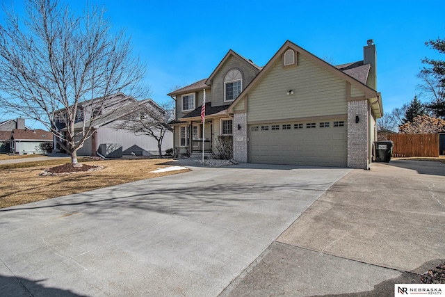 view of front of home featuring a garage, fence, brick siding, and driveway