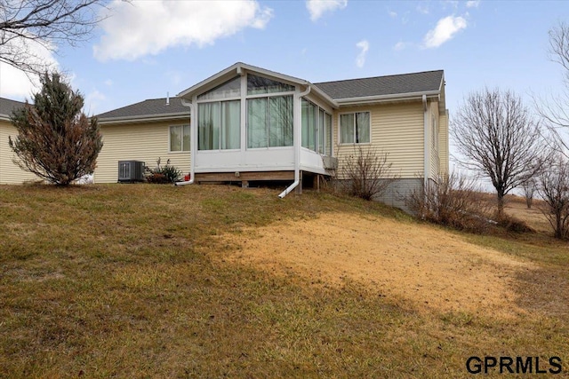 rear view of house featuring a yard, cooling unit, and a sunroom