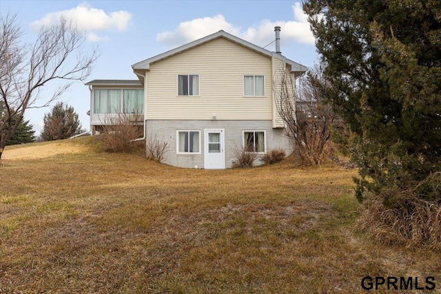 back of property featuring a yard and a sunroom