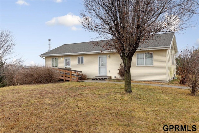 rear view of property featuring entry steps and a yard