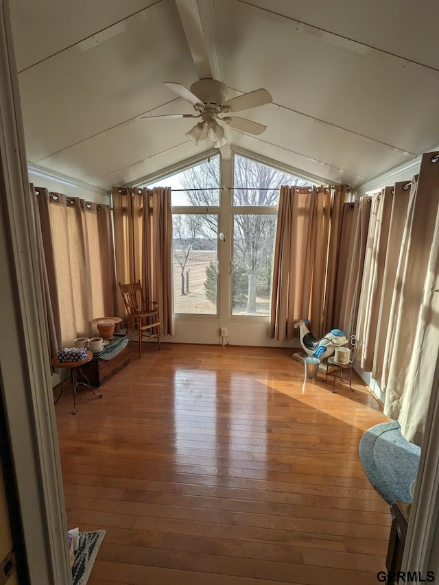 interior space with ceiling fan, lofted ceiling with beams, and light wood-style flooring