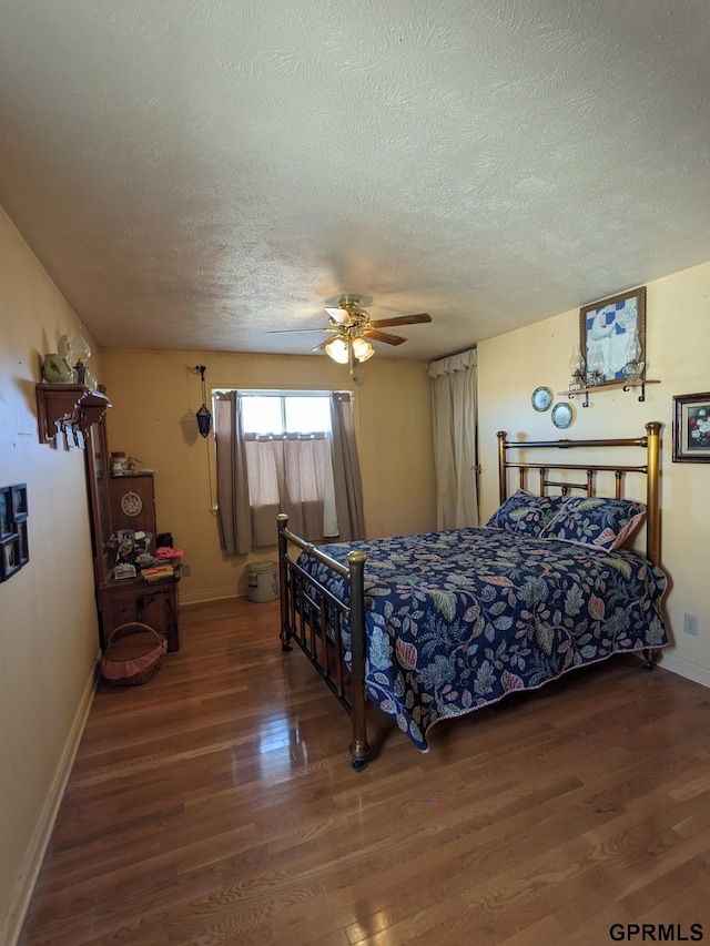 bedroom with a textured ceiling, wood finished floors, baseboards, and ceiling fan