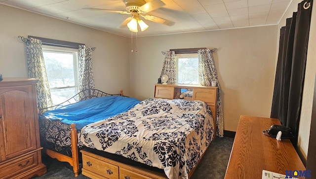 bedroom with dark colored carpet and ceiling fan