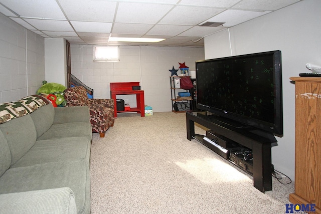 carpeted living room with concrete block wall, a paneled ceiling, and visible vents