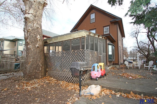 back of property featuring a deck and a sunroom