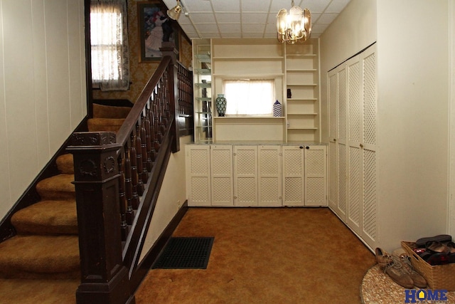 interior space featuring plenty of natural light, carpet, visible vents, and a paneled ceiling