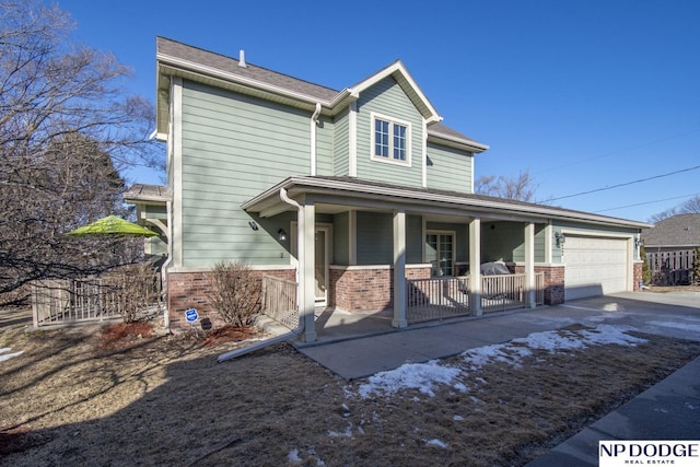 traditional-style house with an attached garage, fence, and brick siding