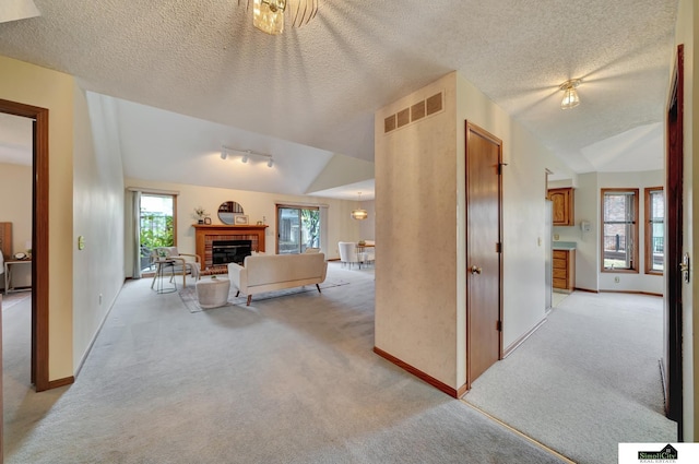 living room featuring light colored carpet, a healthy amount of sunlight, and a glass covered fireplace