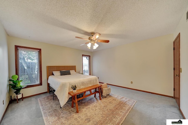 bedroom featuring visible vents, a textured ceiling, baseboards, light colored carpet, and ceiling fan