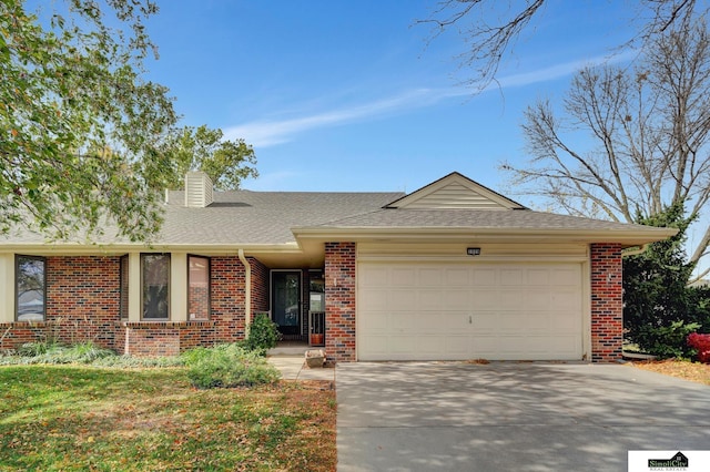 ranch-style house featuring roof with shingles, driveway, an attached garage, a chimney, and brick siding