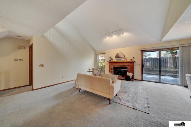 carpeted living area featuring plenty of natural light, a fireplace, baseboards, and vaulted ceiling