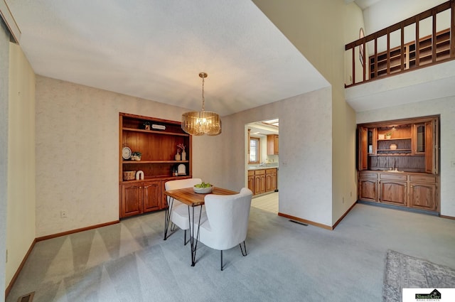 dining area featuring visible vents, a notable chandelier, light colored carpet, and baseboards