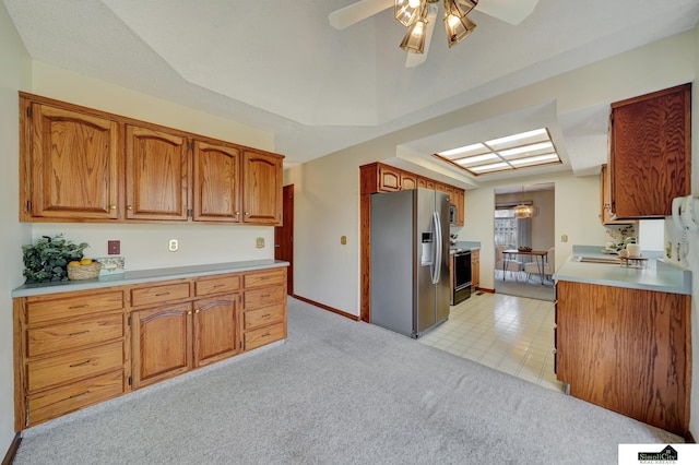 kitchen with brown cabinetry, light colored carpet, light countertops, and stainless steel refrigerator with ice dispenser