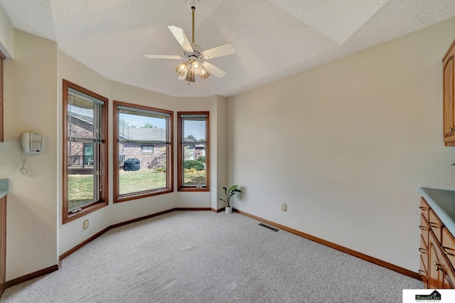 unfurnished dining area featuring ceiling fan, baseboards, visible vents, and light carpet