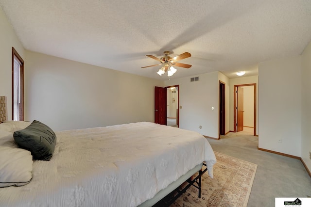 bedroom featuring visible vents, baseboards, light carpet, a textured ceiling, and a ceiling fan