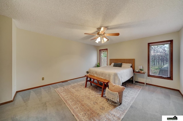 bedroom featuring a textured ceiling, baseboards, carpet floors, and ceiling fan