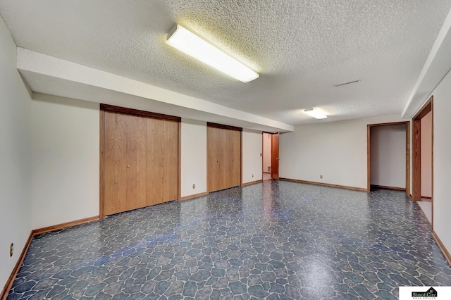 spare room with visible vents, baseboards, and a textured ceiling