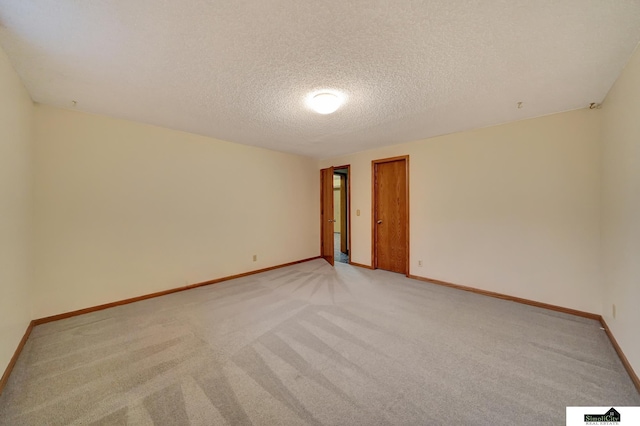 empty room with visible vents, baseboards, a textured ceiling, and light carpet