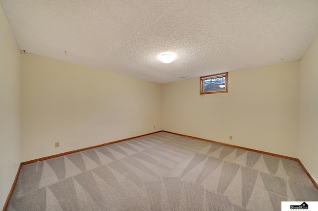 spare room featuring a textured ceiling, visible vents, baseboards, and light carpet