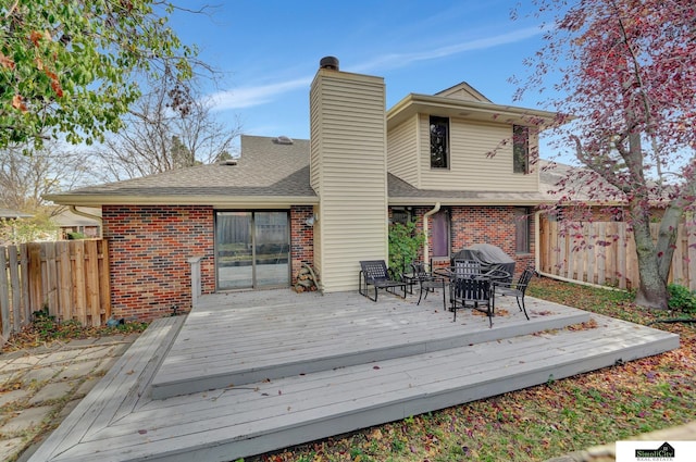 deck with a grill and fence