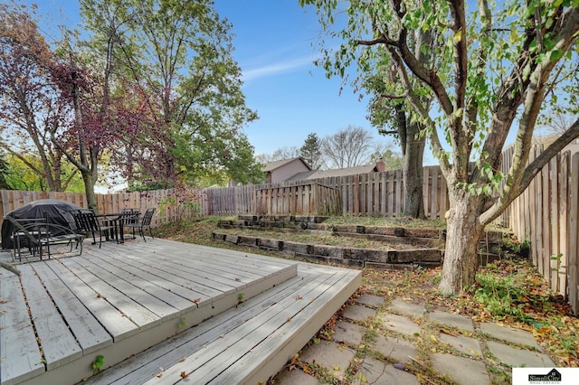 wooden deck featuring outdoor dining area and a fenced backyard