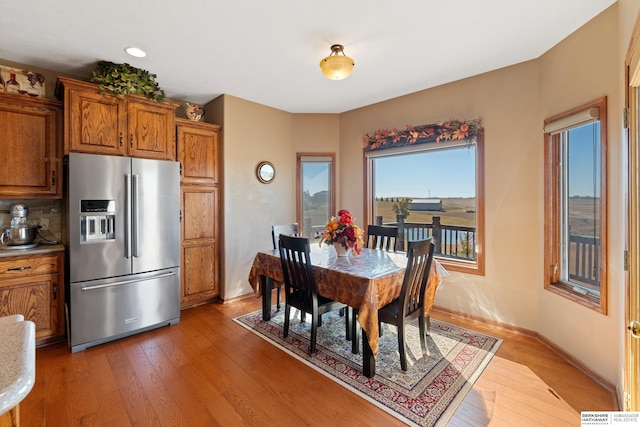 dining space with baseboards and light wood finished floors