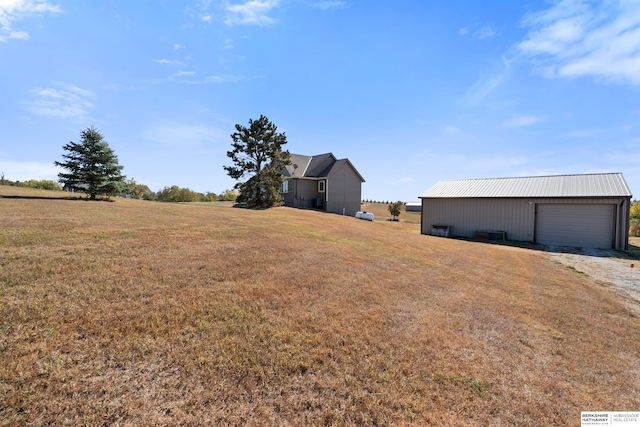 view of yard with a garage, an outdoor structure, and a pole building