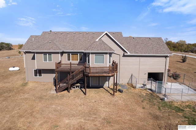 back of house with fence, a wooden deck, concrete driveway, stairs, and roof with shingles