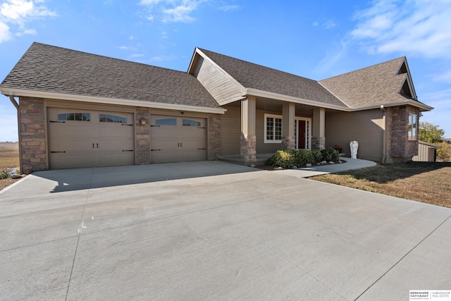 view of front of house with an attached garage, a shingled roof, and concrete driveway