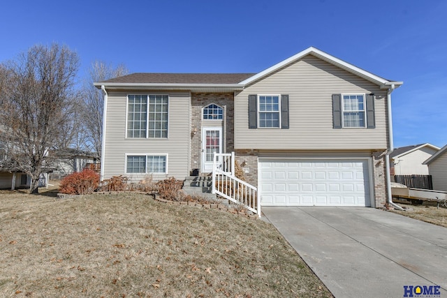 raised ranch featuring brick siding, a garage, and driveway