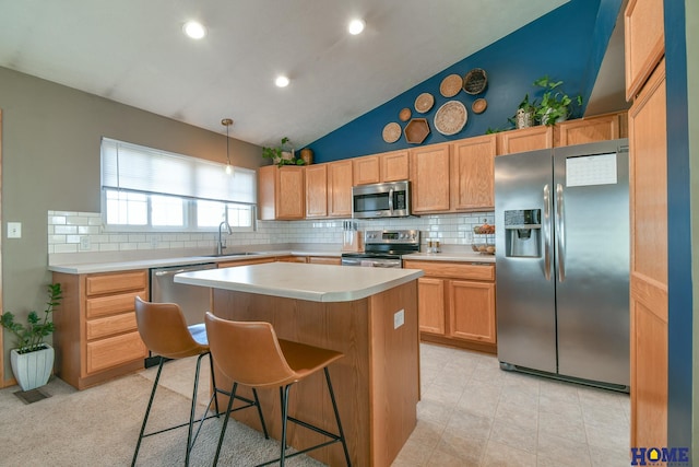 kitchen with tasteful backsplash, a center island, light countertops, stainless steel appliances, and a sink